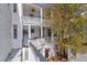 White apartment building featuring private porches, a tree, and a brick courtyard at 35 Society St # D, Charleston, SC 29401