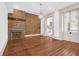 Bright living room with hardwood floors, exposed brick, fireplace, chandelier, and doorway to the kitchen at 35 Society St # D, Charleston, SC 29401
