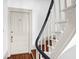 Staircase showcasing wooden steps, white railings, and a black handrail near a door at 35 Society St # D, Charleston, SC 29401