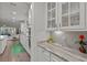 White kitchen boasts granite countertops, tiled backsplash, glass cabinets, and stainless steel appliances at 403 Hidden Meadow Ln, Summerville, SC 29486