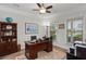 Traditional home office features a wood desk, ceiling fan, and natural light from the window overlooking the yard at 403 Hidden Meadow Ln, Summerville, SC 29486