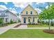 Charming yellow two-story home with a blue door, inviting porch, and freshly manicured lawn at 403 Ripple Park Dr, Summerville, SC 29486