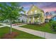 Charming yellow two-story home with a blue door, inviting porch, and freshly manicured lawn at 403 Ripple Park Dr, Summerville, SC 29486