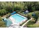 Aerial shot showcasing the pool, tennis court, pond, and clubhouse nestled among mature trees at 4872 Law Blvd, Summerville, SC 29485