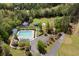 Aerial view featuring a pool, tennis court, playground, and surrounding green space; a community oasis at 4872 Law Blvd, Summerville, SC 29485