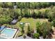 An aerial view showing the community pool, a pond with fountain, playground and sports field surrounded by lush trees at 4872 Law Blvd, Summerville, SC 29485