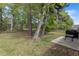 Lush backyard with green grass, mature trees, a patio, and a grill; perfect for outdoor entertaining and relaxation at 4872 Law Blvd, Summerville, SC 29485