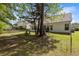 Backyard featuring lush grass, mature trees, and a patio with chairs; fenced-in for added privacy at 4872 Law Blvd, Summerville, SC 29485