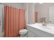 Bright bathroom featuring a white vanity, neutral wall paint, and a shower with an orange patterned curtain at 4872 Law Blvd, Summerville, SC 29485
