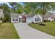 Charming single-story home with a well-manicured lawn, long driveway, and attached garage at 4872 Law Blvd, Summerville, SC 29485