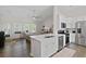 A modern kitchen offers an island with sink, stainless appliances, and white cabinetry with an open floorplan at 4872 Law Blvd, Summerville, SC 29485