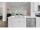 Bright kitchen with stainless steel appliances, white cabinetry, and an island with sink overlooking the living area at 4872 Law Blvd, Summerville, SC 29485