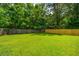 Lush backyard with green grass, mature trees, and a combination wood and wire fence at 505 Laurel Ridge Rd, North Charleston, SC 29418