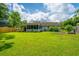 Well-manicured backyard showcasing a lush lawn, mature trees, and a charming screened-in porch for outdoor living at 505 Laurel Ridge Rd, North Charleston, SC 29418