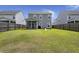 Beautiful view of a green lawn, wood fence, covered patio, and grill with other houses nearby at 5222 American Holly Ln, Ladson, SC 29456