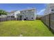 A spacious backyard featuring green lawn, wood fence and a covered patio with a grill at 5222 American Holly Ln, Ladson, SC 29456