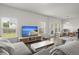 A beautifully lit living room with modern decor, large windows, and hardwood floors at 5222 American Holly Ln, Ladson, SC 29456