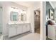 Well-lit bathroom with double sinks, modern fixtures, and an adjacent walk-in closet at 5400 Turning Tide, North Charleston, SC 29420