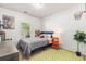 Bright bedroom features a twin bed, neutral walls, and a green geometric rug at 5400 Turning Tide, North Charleston, SC 29420