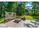 Spacious backyard featuring a stone fire pit with retaining wall and a lush, green lawn at 5692 Barbary Coast Rd, Hollywood, SC 29449