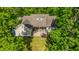 Aerial view of a home featuring a backyard with a patio seating area, fire pit, green lawn, and surrounded by trees at 5692 Barbary Coast Rd, Hollywood, SC 29449