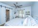 Bright bedroom features a sliding barn door to the bathroom, desk, ceiling fan and a large window at 5692 Barbary Coast Rd, Hollywood, SC 29449
