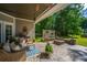 Inviting covered patio with comfortable seating, a stylish rug, and a stone fire pit with backyard views at 5692 Barbary Coast Rd, Hollywood, SC 29449