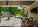 Relaxing covered patio featuring a stone fire pit, outdoor seating, and views of the landscaped backyard at 5692 Barbary Coast Rd, Hollywood, SC 29449