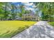 Inviting home with a lush green lawn, mature trees, and a long driveway at 5692 Barbary Coast Rd, Hollywood, SC 29449