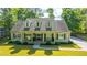 Inviting exterior with a well-manicured lawn, dormer windows, and a welcoming front porch with seating at 5692 Barbary Coast Rd, Hollywood, SC 29449