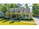Inviting exterior with a well-manicured lawn, dormer windows, and a welcoming front porch with seating at 5692 Barbary Coast Rd, Hollywood, SC 29449