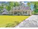 Inviting home featuring a spacious front yard, covered porch with seating, and an expansive driveway at 5692 Barbary Coast Rd, Hollywood, SC 29449