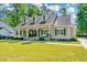 Charming home with a manicured lawn, a covered porch with seating, and classic architectural details at 5692 Barbary Coast Rd, Hollywood, SC 29449
