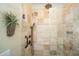 Walk-in shower featuring travertine tile, a hand-held shower head, and a built-in bench at 5692 Barbary Coast Rd, Hollywood, SC 29449