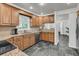 Well-lit kitchen with granite countertops, stainless steel appliances, and dark tile floors create a contemporary look at 615 Fairington Dr, Summerville, SC 29485