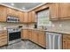 Spacious kitchen features stainless steel appliances, granite counters, and natural wood cabinets for a warm, inviting space at 615 Fairington Dr, Summerville, SC 29485