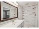 Modern bathroom with white subway tile walls, glass shower door, and vanity with a decorative mirror at 620 Clearview Dr, Charleston, SC 29412