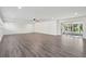 Bright living room with gray wood floors, ceiling fan, and sliding glass doors to sunroom at 620 Clearview Dr, Charleston, SC 29412