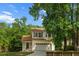 Traditional-style home with a 2-car garage, and a welcoming front porch, surrounded by lush trees, and a beautiful lawn at 675 Fair Spring Dr, Charleston, SC 29414