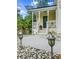 Inviting covered front porch with white railings, decorative anchor, and a well-lit walkway enhances the home's curb appeal at 675 Fair Spring Dr, Charleston, SC 29414