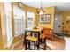 Eat-in kitchen featuring bright yellow walls, natural light, and a cozy dining table at 675 Fair Spring Dr, Charleston, SC 29414