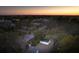 Evening aerial shot of a residential area, featuring charming homes nestled among lush trees with a serene sunset backdrop at 706 White Oak Dr, Charleston, SC 29407