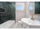 Modern bathroom featuring a tub with tiled surround, stylish fixtures, and natural light at 706 White Oak Dr, Charleston, SC 29407