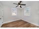 Bright bedroom featuring wood-look flooring, ceiling fan, and two windows for natural light at 706 White Oak Dr, Charleston, SC 29407