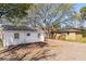 Rear exterior showing home with mature trees, side yard and ample parking at 706 White Oak Dr, Charleston, SC 29407