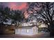 A white brick single-story home in a large lot with mature trees and gravel driveway at 706 White Oak Dr, Charleston, SC 29407