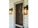 Close-up of the front door with stylish lanterns, screen door and white brick at 706 White Oak Dr, Charleston, SC 29407