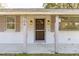 Inviting front porch featuring a classic wooden door and stylish wall-mounted lanterns at 706 White Oak Dr, Charleston, SC 29407