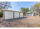 Garage with white panel doors and graveled parking area, perfect for storage and vehicles at 706 White Oak Dr, Charleston, SC 29407