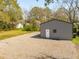 Side view of garage with a white entry door, window and gravel parking area at 706 White Oak Dr, Charleston, SC 29407